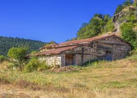 vieux abandonné maison avec carrelé rouge toit avec bleu ciel photo