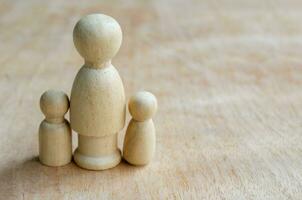 en bois figure représenter une mère avec deux les enfants. famille concept photo