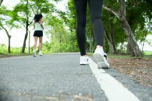 coureur athlète fonctionnement sur route dans parc. femme aptitude le jogging faire des exercices bien-être concept. photo