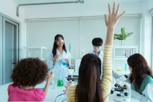 dans le science Salle de classe, un asiatique enfant scientifique expérimenter avec scientifique formules avec produits chimiques photo