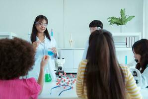 dans le science Salle de classe, un asiatique enfant scientifique expérimenter avec scientifique formules avec produits chimiques photo