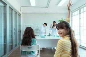 dans le science Salle de classe, un asiatique enfant scientifique expérimenter avec scientifique formules avec produits chimiques photo