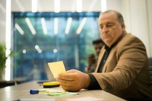 Sénior homme d'affaire travail avec les documents et mature homme d'affaire travail sur portable ordinateur dans Bureau photo