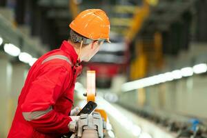 après le électrique train est garé dans le électrique train réparation boutique, un électrique train technicien avec outils inspecter le chemin de fer et électrique les trains dans conformité avec le inspection rond photo