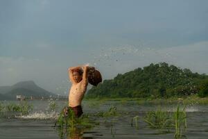 les pêcheurs en utilisant traditionnel pêche équipement après contagieux poisson, nettoyer en haut et jouer dans le l'eau. photo