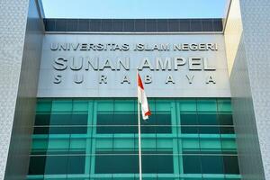 surabaya, Indonésie. 08 15 2023. indonésien rouge et blanc drapeau en volant dans de face de un de le principale bâtiments de sunan ampel Etat islamique Université uin, conférence. photo