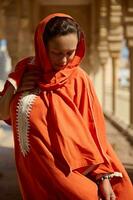 portrait de milieu est musulman femme avec tête couvert dans hijab, posant contre le mosquée marbre Colonnes Contexte photo