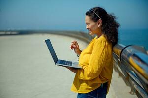 souriant femme en utilisant ordinateur portable, parlant avec sa affaires les partenaires ou copains via vidéo lien. en ligne communication. photo