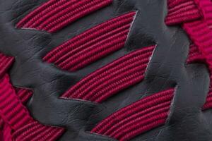 fragment de rouge noir baskets tissu. le texture de le Matériel de des sports des chaussures photo