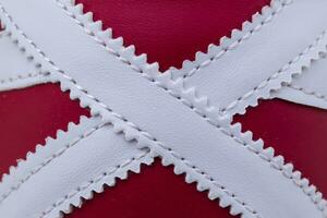 fragment de rouge et blanc baskets tissu. le texture de le Matériel de des sports des chaussures photo