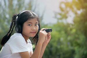 asiatique mignonne fille détient jumelles à regarder des oiseaux dans le forêt, des oiseaux et la nature étude concept. photo