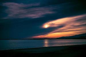 coucher de soleil spectaculaire sur le fond de la mer et du littoral photo