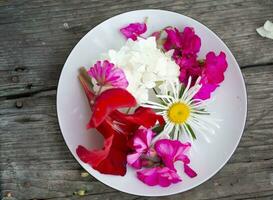 sur une blanc assiette magnifique multicolore fleurs sur une en bois Contexte photo