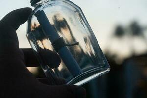 une homme main en portant une bouteille avec une message photo