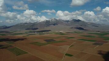 drone vue plus de les terres agricoles contre neigeux Montagne photo