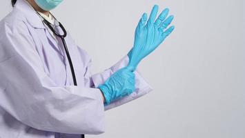 porter des gants. un médecin asiatique porte un gant pour les mains en caoutchouc nitrile bleu.