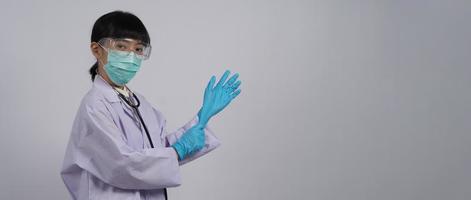 porter des gants. un médecin asiatique porte un gant pour les mains en caoutchouc nitrile bleu.