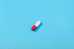 Capsule de pilule médicale isolée sur fond bleu photo