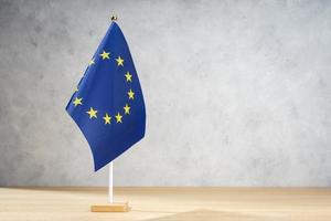 drapeau de table de l'union européenne sur un mur texturé blanc. espace de copie photo