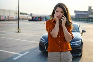 femme conductrice utilisant un téléphone portable pendant une voiture problématique. panne ou voiture cassée sur la route. concept d'assurance, d'entretien et de service de véhicule photo