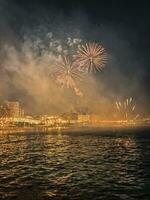 coloré feux d'artifice dans le nuit ciel sur le front de mer de alicante Espagne photo