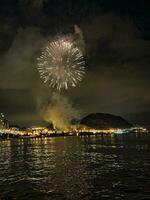 coloré feux d'artifice dans le nuit ciel sur le front de mer de alicante Espagne photo