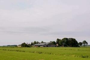 une ferme avec une Grange et des arbres dans le distance photo