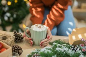 femme en portant tasse de aromatique cacao avec guimauves. Noël veille avec tasse de savoureux chaud Chocolat confortable vacances atmosphère à Accueil photo