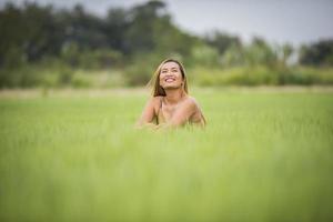jeune femme assise se sentir bien dans le champ d'herbe. photo