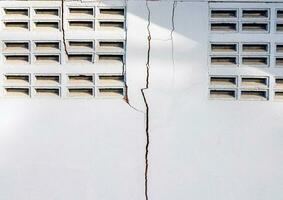 des fissures dans le ciment mur blanc ciment de bâtiments endommagé par tremblements de terre photo