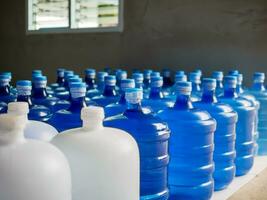Plastique gros bouteilles ou blanc et bleu gallons de purifié en buvant l'eau à l'intérieur le production doubler. l'eau boisson usine photo