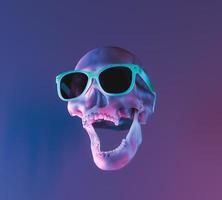 crâne avec éclairage au néon et lunettes de soleil photo