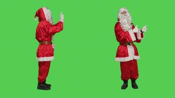 Père Noël Est-ce que non signe et donne les pouces en haut sur tous les deux côtés sur le plein corps écran vert studio, portant de fête rouge costume et chapeau. père Noël exprimer frustration, Faire comme accord symbole. photo