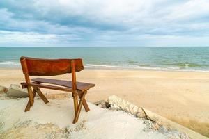 banc en bois sur la plage avec fond de plage de la mer photo