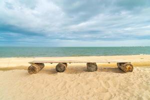 banc en bois sur la plage avec fond de plage de la mer photo