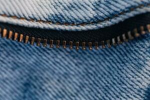 ancien jeans avec une fermeture éclair, fermer. mode bleu denim en tissu texture photo