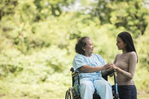 petite-fille parlant avec sa grand-mère assise sur un fauteuil roulant photo