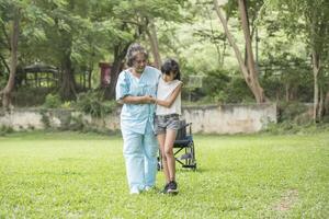 grand-mère âgée en fauteuil roulant avec sa petite-fille à l'hôpital photo