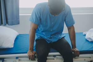 asiatique Masculin patient mensonge sur lit avec visage masque dans récupération pièce dans hôpital salle. tout gens portant masque à prévenir covid19 virus infection pendant coronavirus pandémie. le homme se sent solitaire et trou. photo