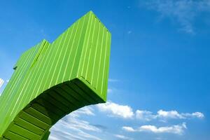 une incurvé vert en bois cambre vu de au dessous de contre une bleu ciel Contexte photo