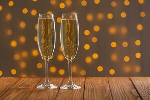 des lunettes avec Champagne sur une en bois Contexte contre une bokeh Contexte de lumières photo