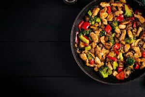 remuer frire avec poulet, champignons, brocoli et poivrons. chinois aliments. Haut voir, aérien photo