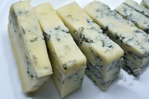 tranché fromage avec bleu moule sur une blanc plaque. délicieux petit déjeuner avec fromage. photo