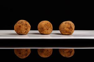 magnifique bonbons truffe sur une blanc assiette sur une noir Contexte photo