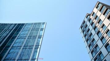 verre façade de le bâtiments avec une bleu ciel. grattes ciels dans le affaires ville centre.. Contexte de moderne verre bâtiments. photo