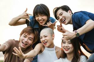 image de une groupe de Jeune asiatique gens en riant Heureusement ensemble photo