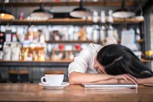 femme asiatique se repose et dort dans un café photo