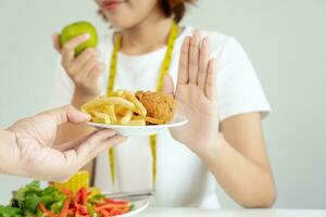 svelte femelle corps embrouiller français frites et frit poulet. femme dans restaurant atteint poids perte objectif pour en bonne santé vie, fou à propos minceur, mince taille, nutritionniste. régime, corps forme. photo