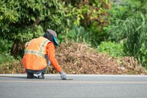 ouvrier portant uniforme est rayures avec mesure sur le route photo