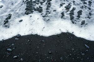 mer vague sur volcanique noir le sable plage dans été photo